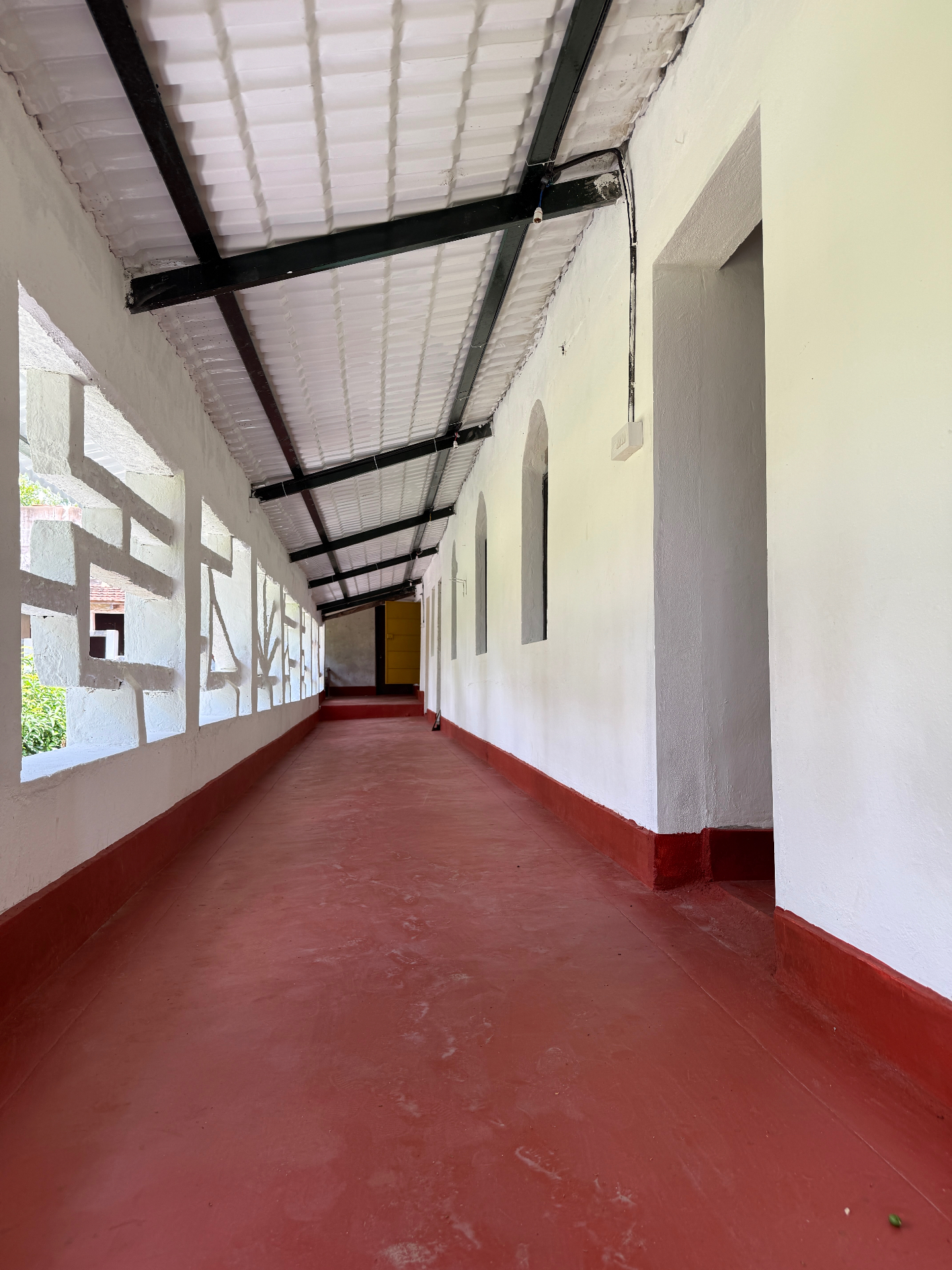 Long corridor at CraftyRooster framed by patterned openings and soft daylight