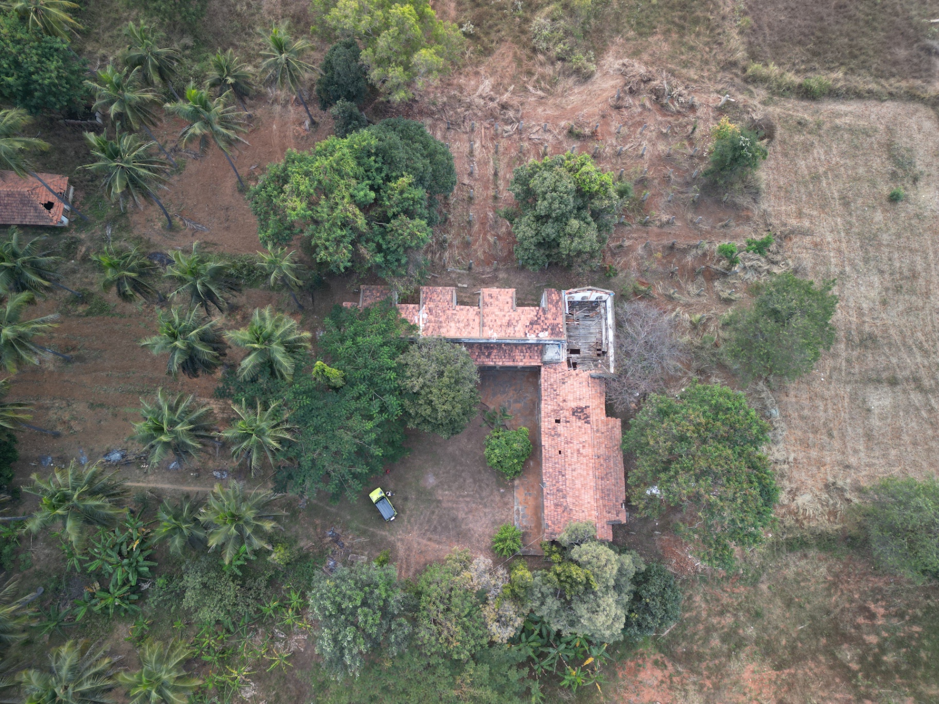 Aerial view of the CraftyRooster sanctuary campus with traditional tile roofs and surrounding farmland