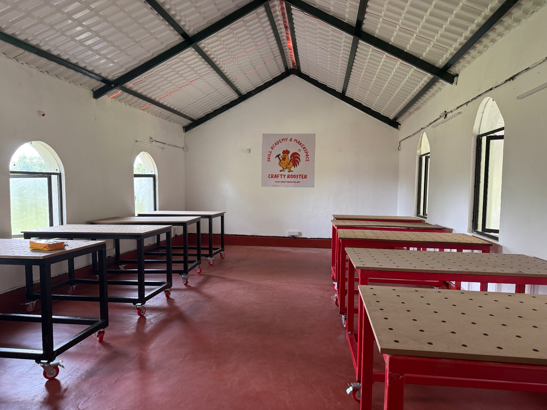 CraftyRooster makerspace studio with custom worktables and arched windows